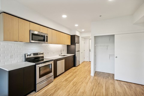 a renovated kitchen with wood flooring and stainless steel appliances