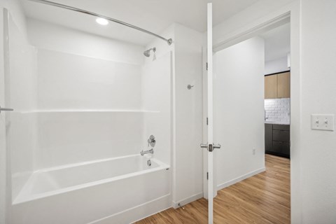 a white bathroom with a tub and a sliding glass door