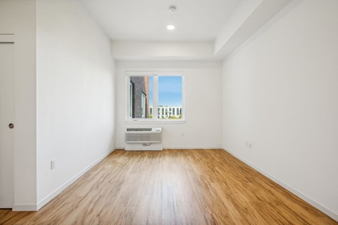 a living room with white walls and a window