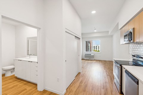 a renovated kitchen with white walls and wood floors