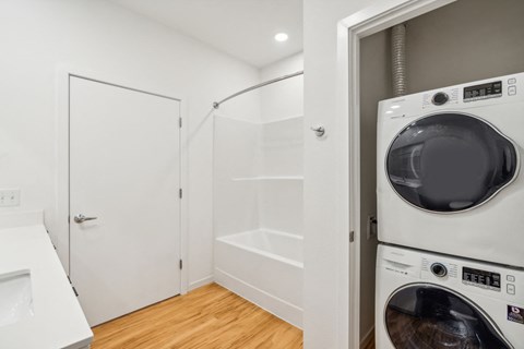 a white washer and dryer in a laundry room with a white closet
