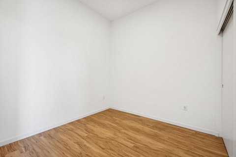 an empty room with white walls and wooden floors