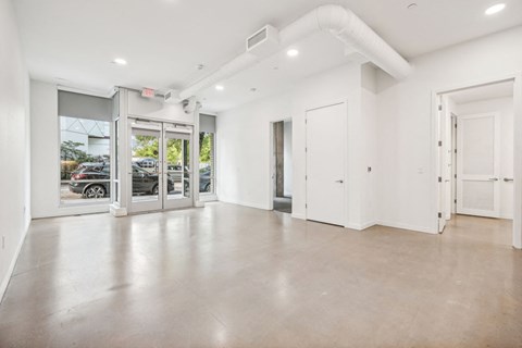 a large empty room with white walls and glass doors