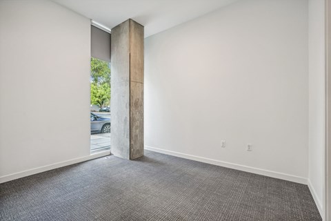 a room with white walls and a window and a carpeted floor