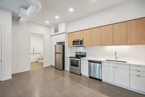 a kitchen with white cabinets and stainless steel appliances