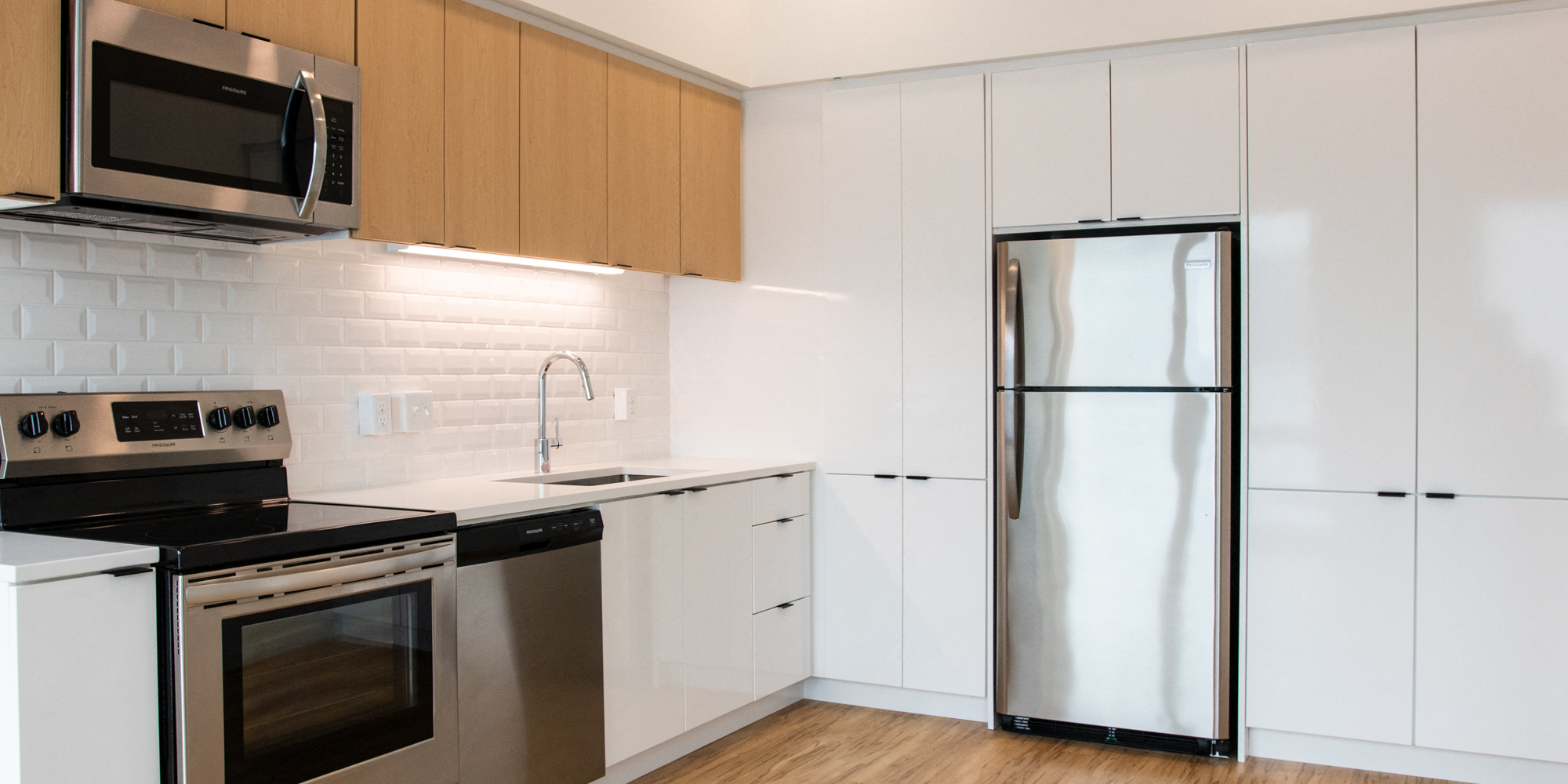 a kitchen with white cabinets and a stainless steel refrigerator