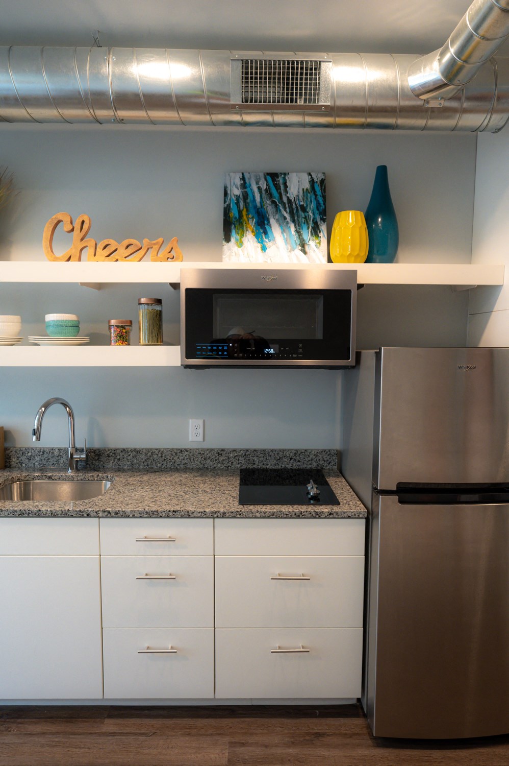 a kitchen with white cabinets and a counter top and a refrigerator