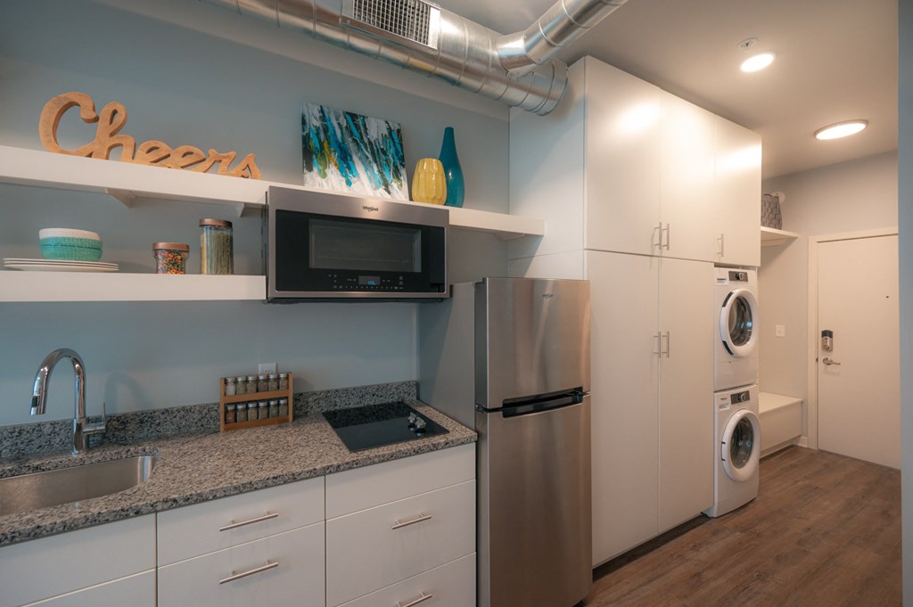 a kitchen with white cabinets and a stainless steel refrigerator