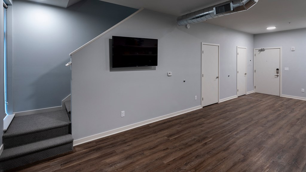 a living room with wood floors and a wall mounted tv