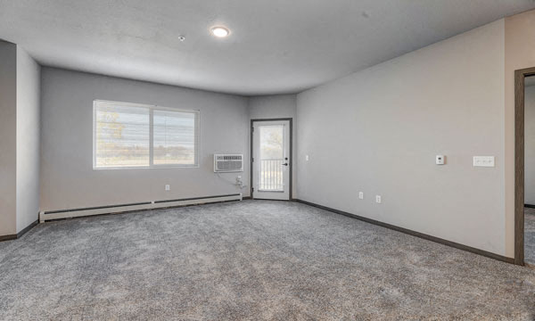 the living room is empty and has a door to the balcony