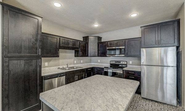 a kitchen with stainless steel appliances and marble counter tops
