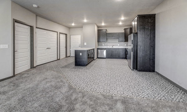 a kitchen and a living room with a refrigerator and a sink