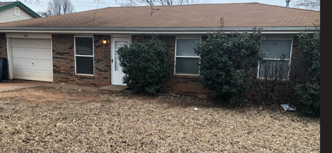 A brick house with a white garage door and a white door.