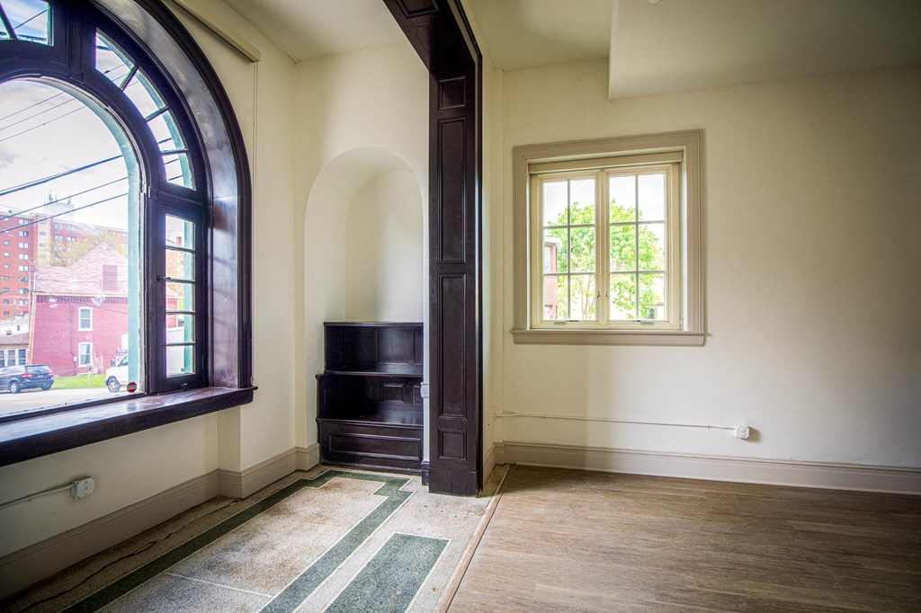 a living room with a large window and a wood floor