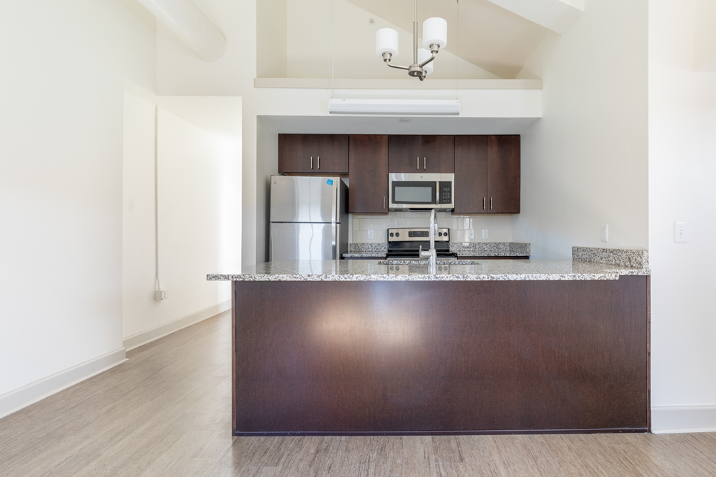 a kitchen with a granite counter top and a stainless steel refrigerator