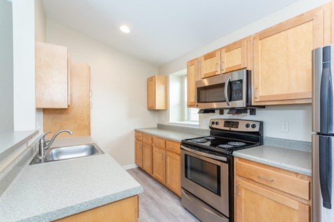 A kitchen with wooden cabinets and a black stove top oven.