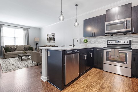 A modern kitchen with dark wood cabinets and stainless steel appliances.