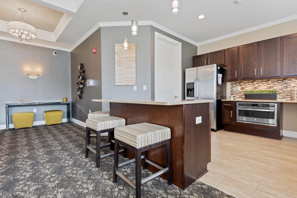 a kitchen and living room with a bar and stools