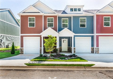 a house with two garage doors and a lawn in front of it