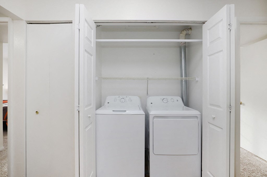a washer and dryer in a closet with white doors