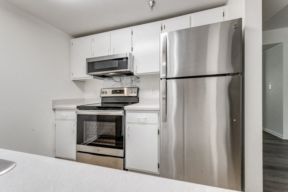 a kitchen with stainless steel appliances and white cabinets