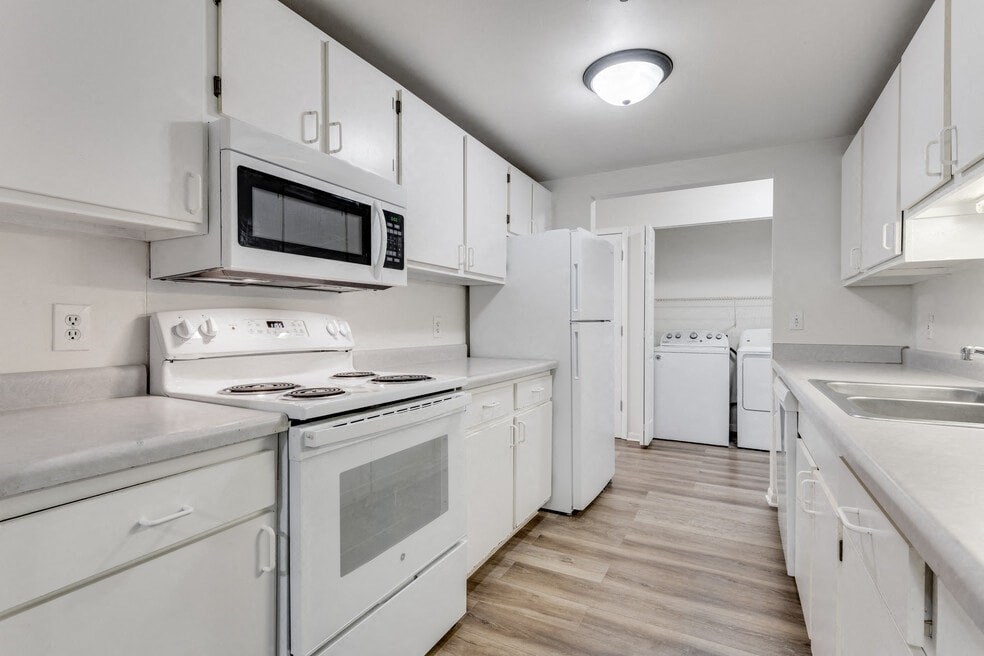 a white kitchen with white appliances and white cabinets