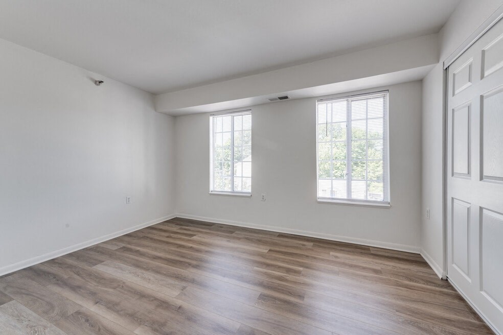 an empty living room with white walls and wood floors