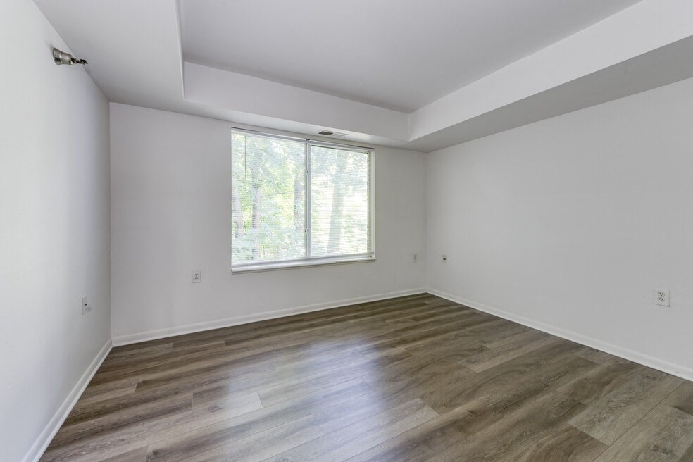 an empty room with wood floors and a window