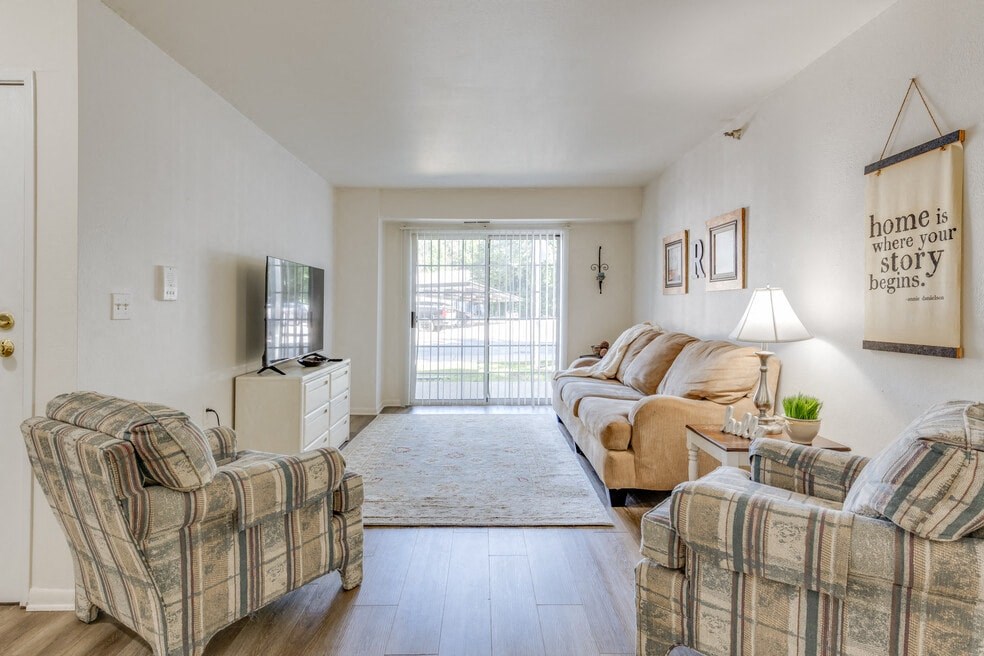 a living room with couches and chairs and a sliding glass door