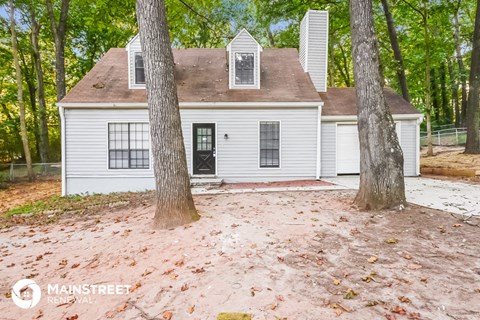 a small white house with two trees in front of it