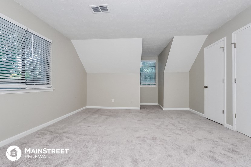 the spacious living room with carpet and white walls