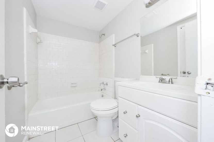 a white bathroom with a white toilet and tub and a sink