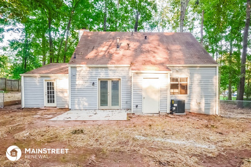 a small white house with trees in the background