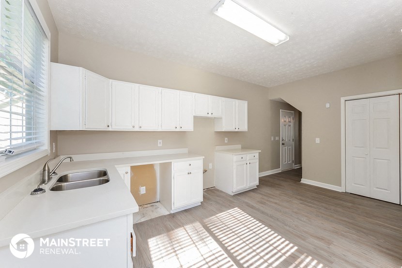 a large white kitchen with white cabinets and a sink