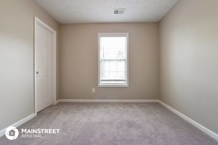 an empty room with a window and a door