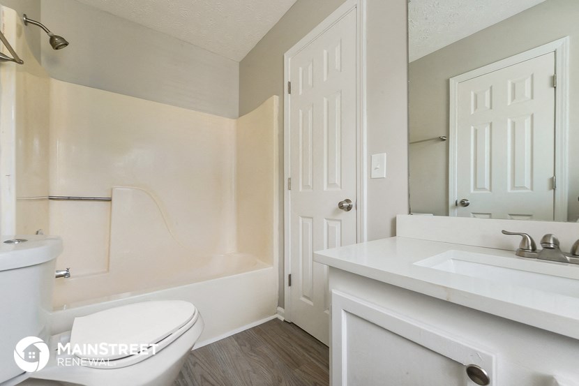 a bathroom with a toilet and a sink and a bath tub