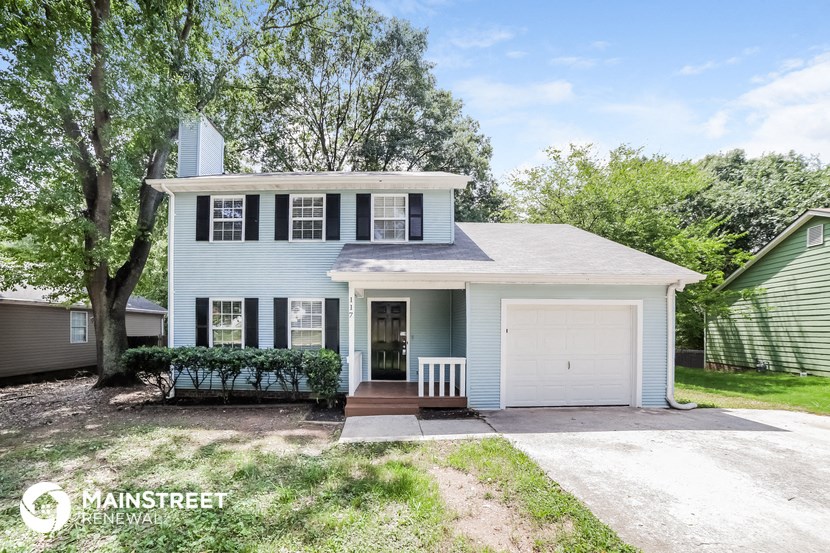a blue house with a white door and a white garage