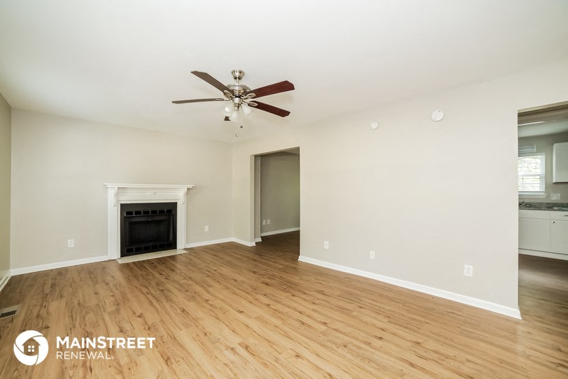 the living room with fireplace and ceiling fan