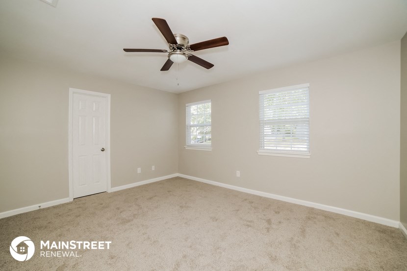 the master bedroom has a ceiling fan and carpeted flooring