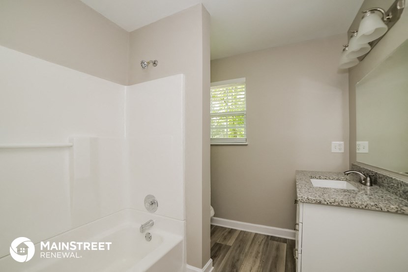 a bathroom with a tub and a sink and a mirror