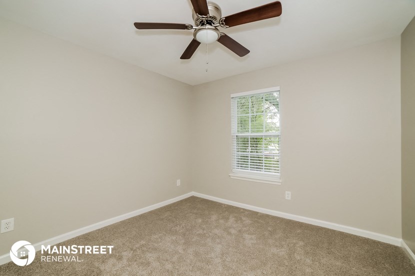 the master bedroom has a ceiling fan and a carpeted floor