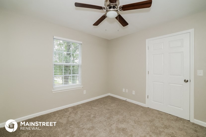 the master bedroom has a ceiling fan and carpeted flooring