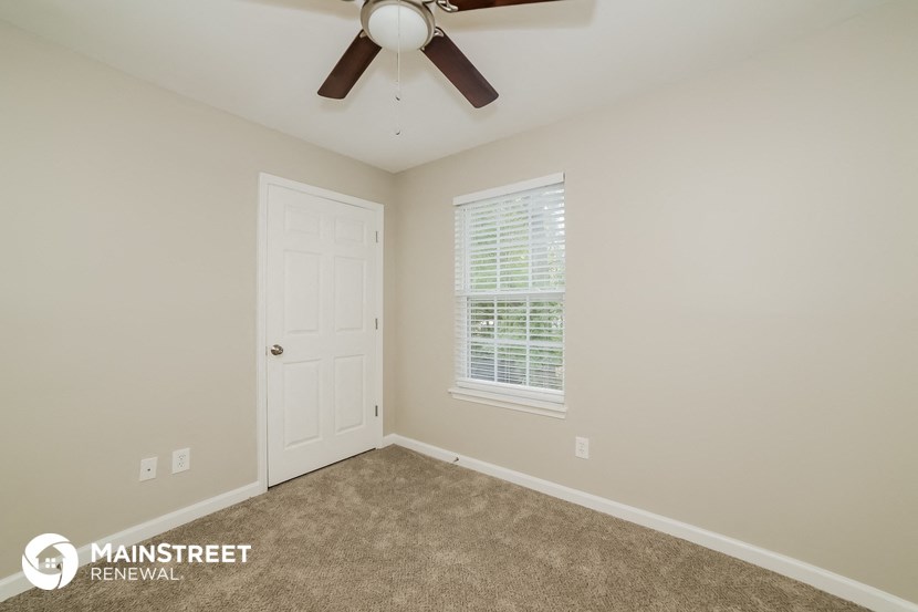 the upstairs bedroom with carpet and a ceiling fan