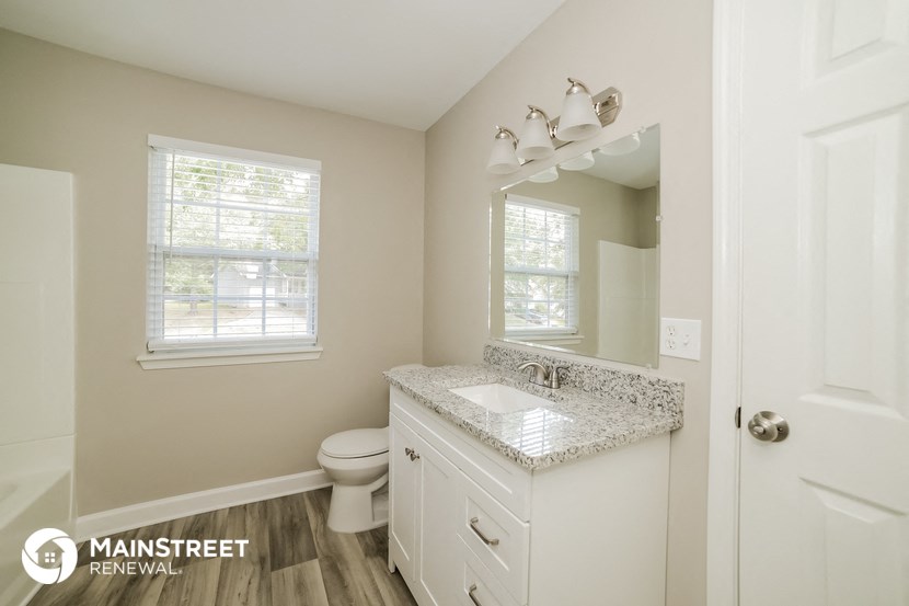 a bathroom with a toilet and a sink and a mirror