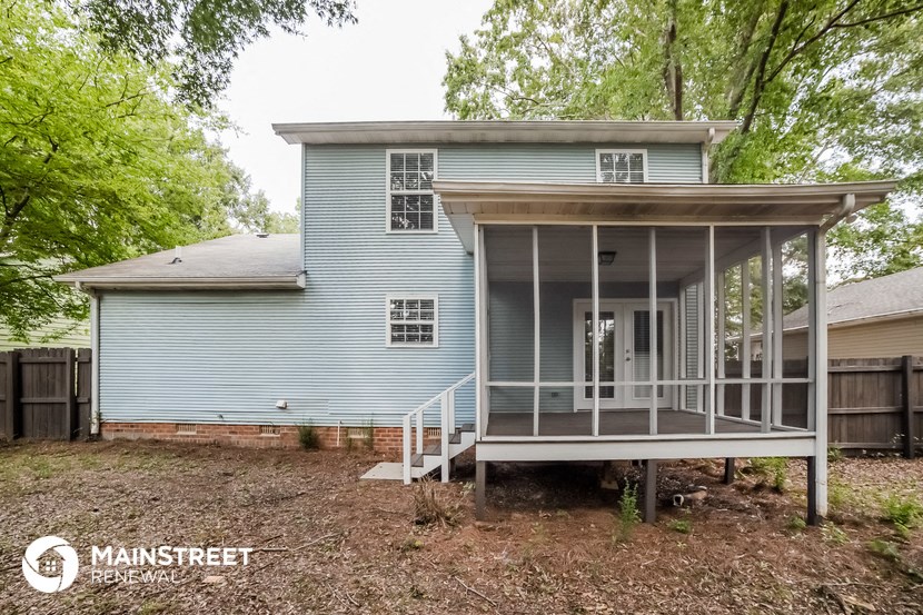 the back of a blue house with a screened porch