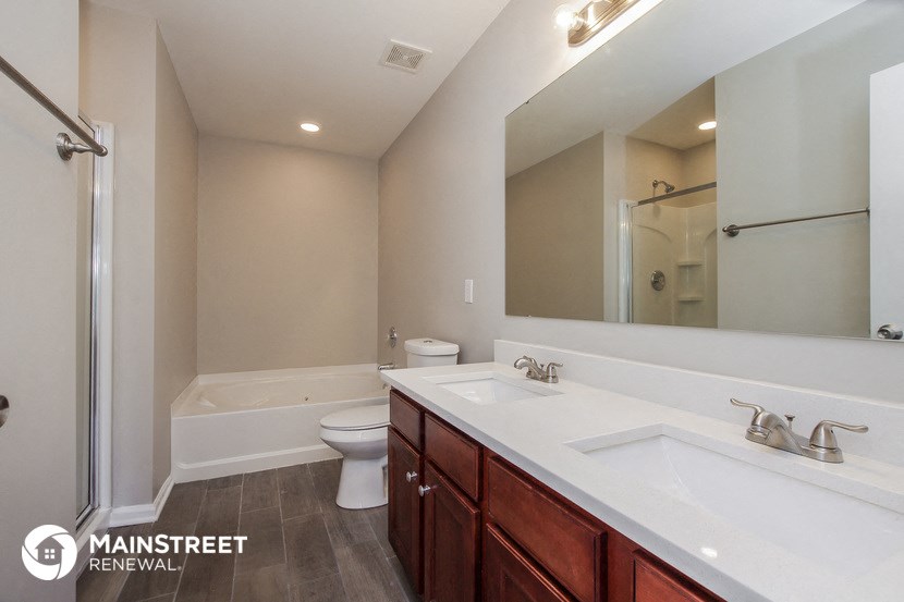 a bathroom with two sinks and a shower and a toilet