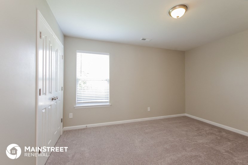 a room with carpet and a door and a window