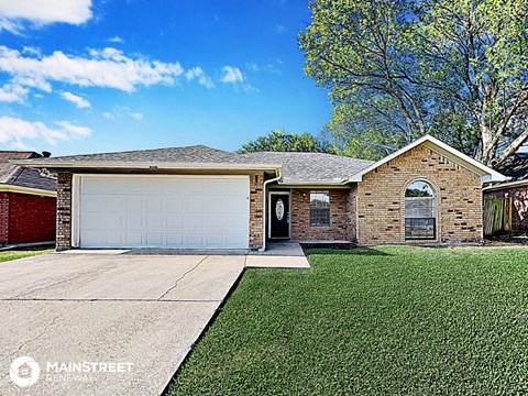 the front of a brick house with a white garage door