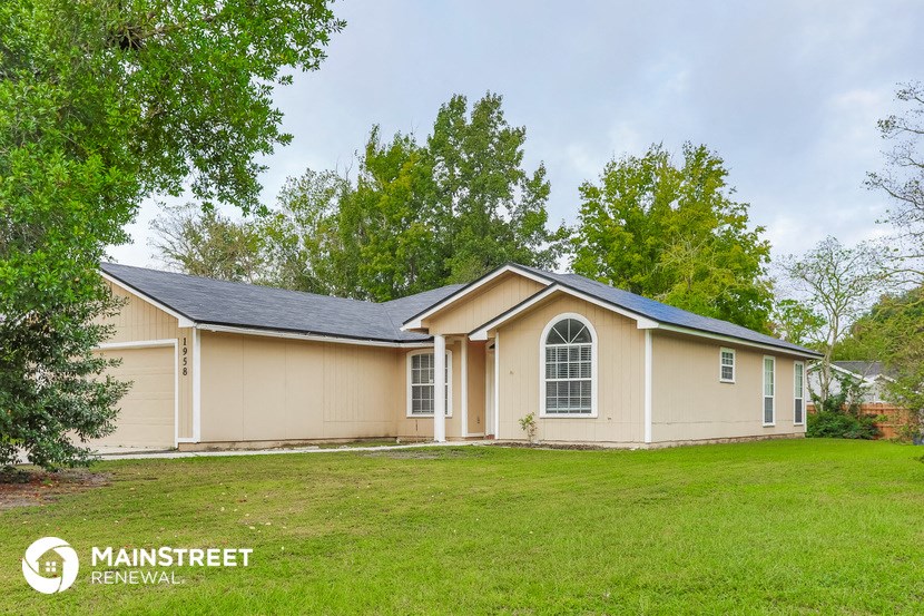 a beige and tan house with a grassy yard