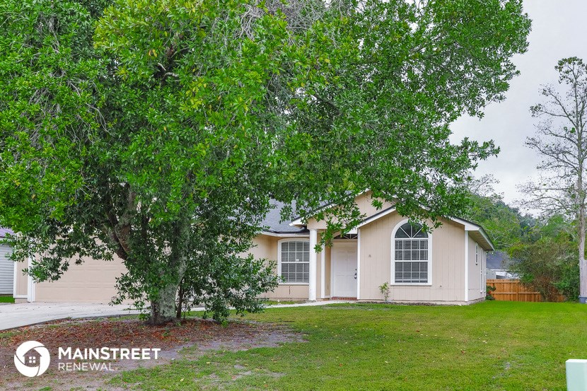 a home with a large tree in front of it